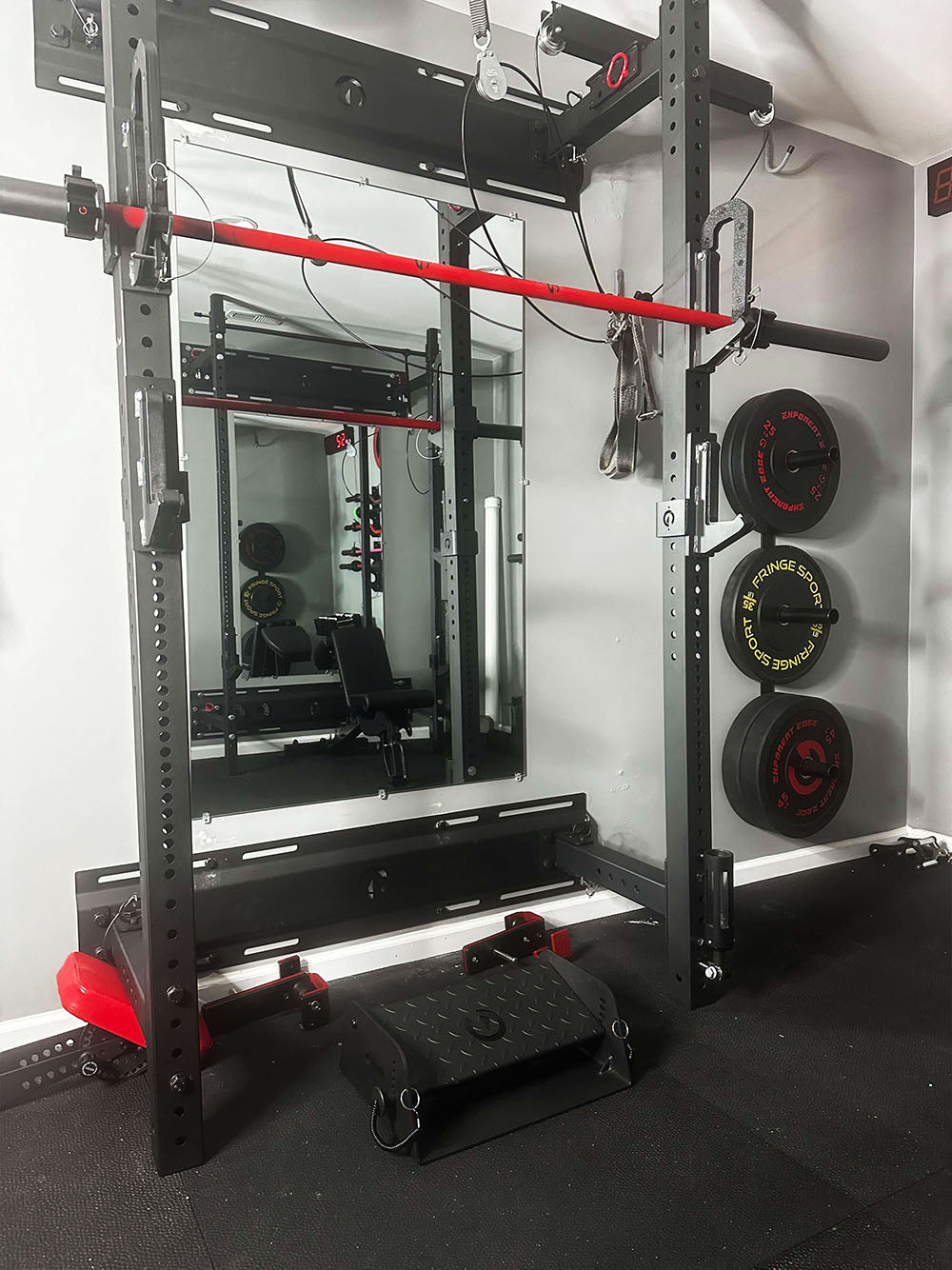 The Calf Cup rack attachment is the best calf solution for those looking to train calves at home but also use the device as a standard J-Cup. This image presents a set of Calf Cups on a power rack supporting a barbell.