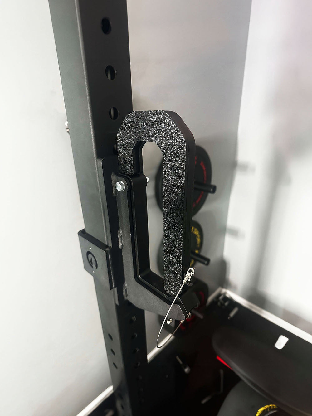 The Adjustable Calf Raise Block and Calf Cup Set are the perfect combination for calf workouts. This image presents a Calf Cup attached to a power rack.