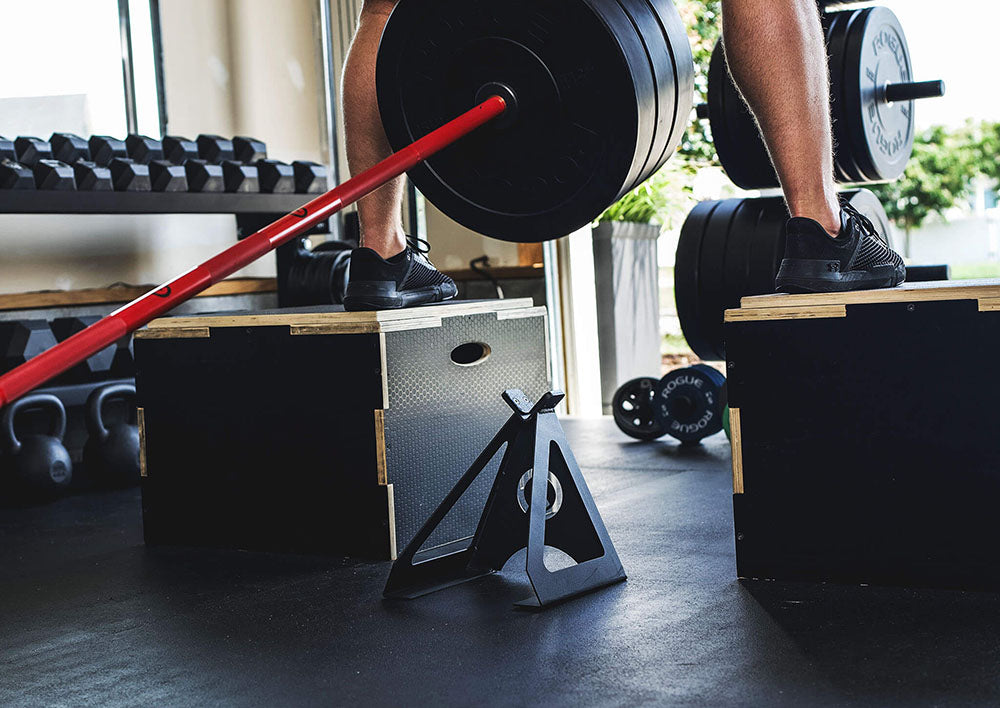 The Edge Landmine Jack is a compact landmine stand that takes the pain out of loading, reloading, and unloading heavy plates onto a barbell while using a landmine. This image presents the Edge Landmine Jack being used for an elevated landmine workout.