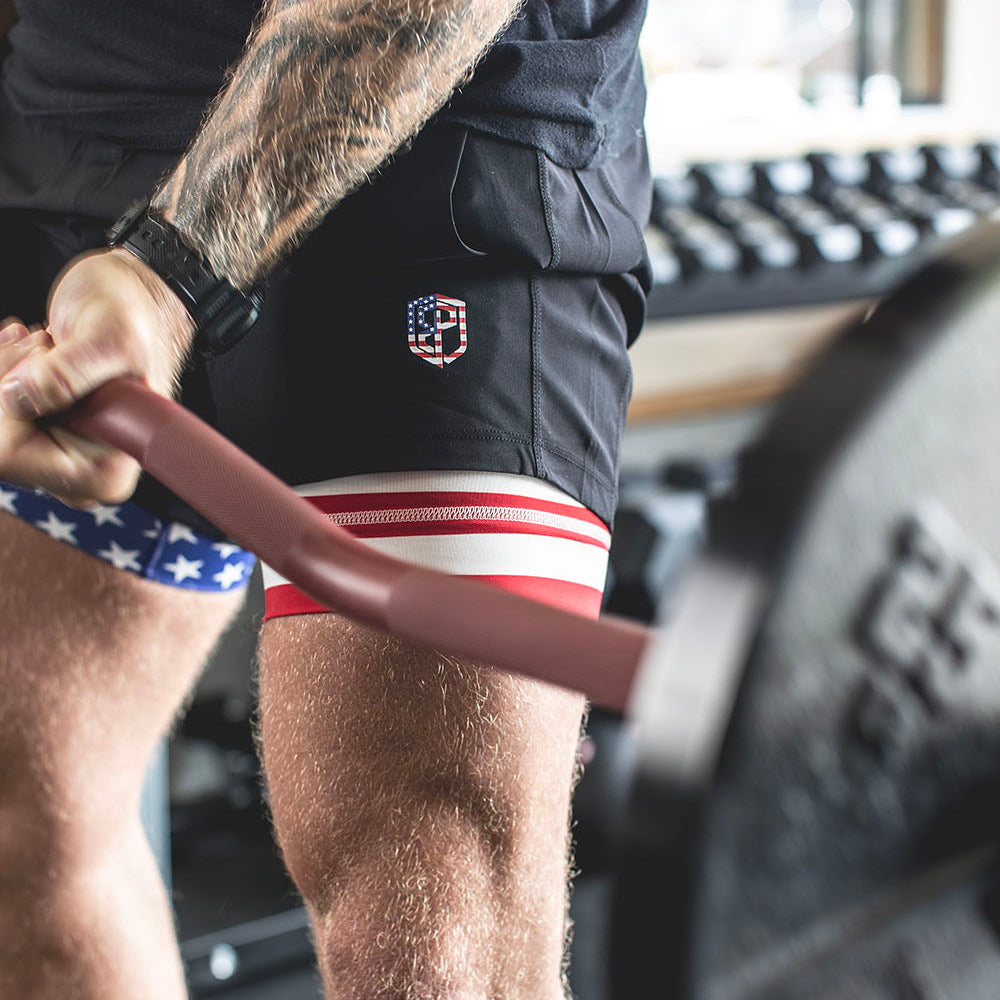 The Edge Bar is a mix between a shortened cambered bar and an EZ Bar. Perfect for enhanced bicep workouts, chest workouts, and more. This image presents the Edge Rackable Cambered Bar being used for a bicep workout.