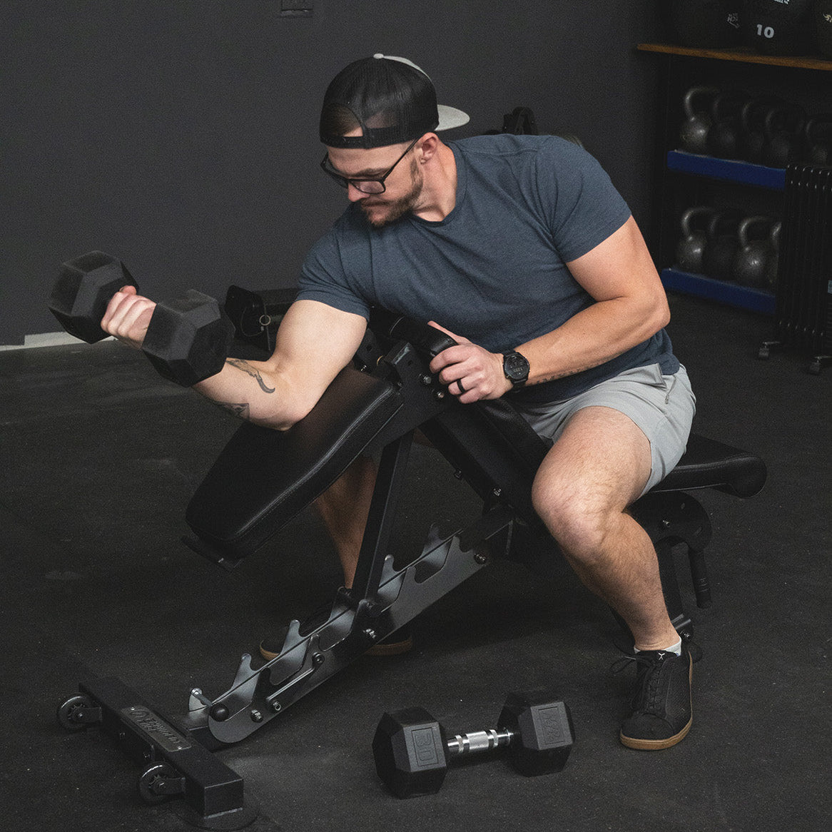 Man doing preacher curls in the Half Bench configuration on the Infinity Bench by Exponent Edge