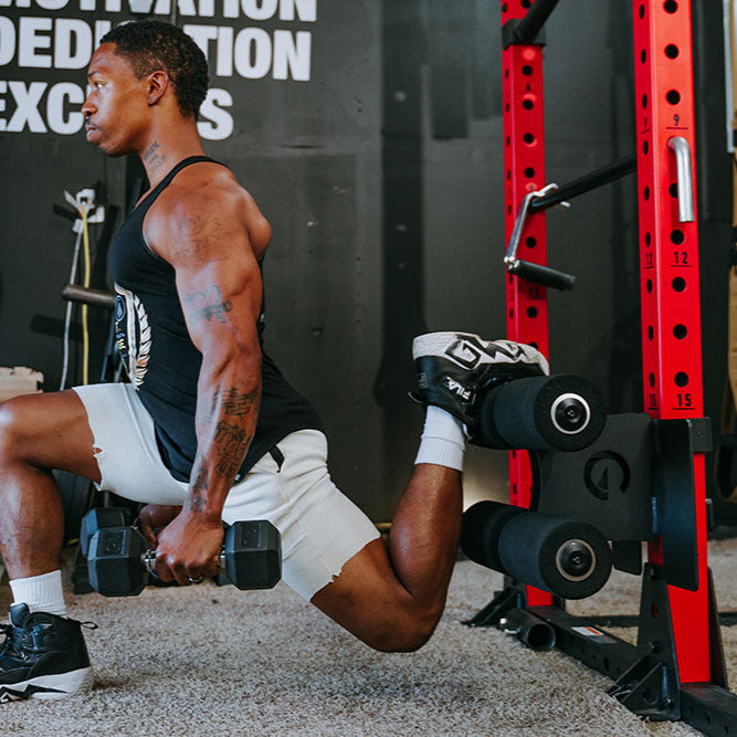 This Rack Mounted Glute Ham Developer is less bulky and lower priced than conventional GHDs. Perfect for glute workouts, ab workouts, and hamstring workouts. This image presents the Rack Mounted Glute Ham Developer being used by a man doing a lunge workout in a garage gym.