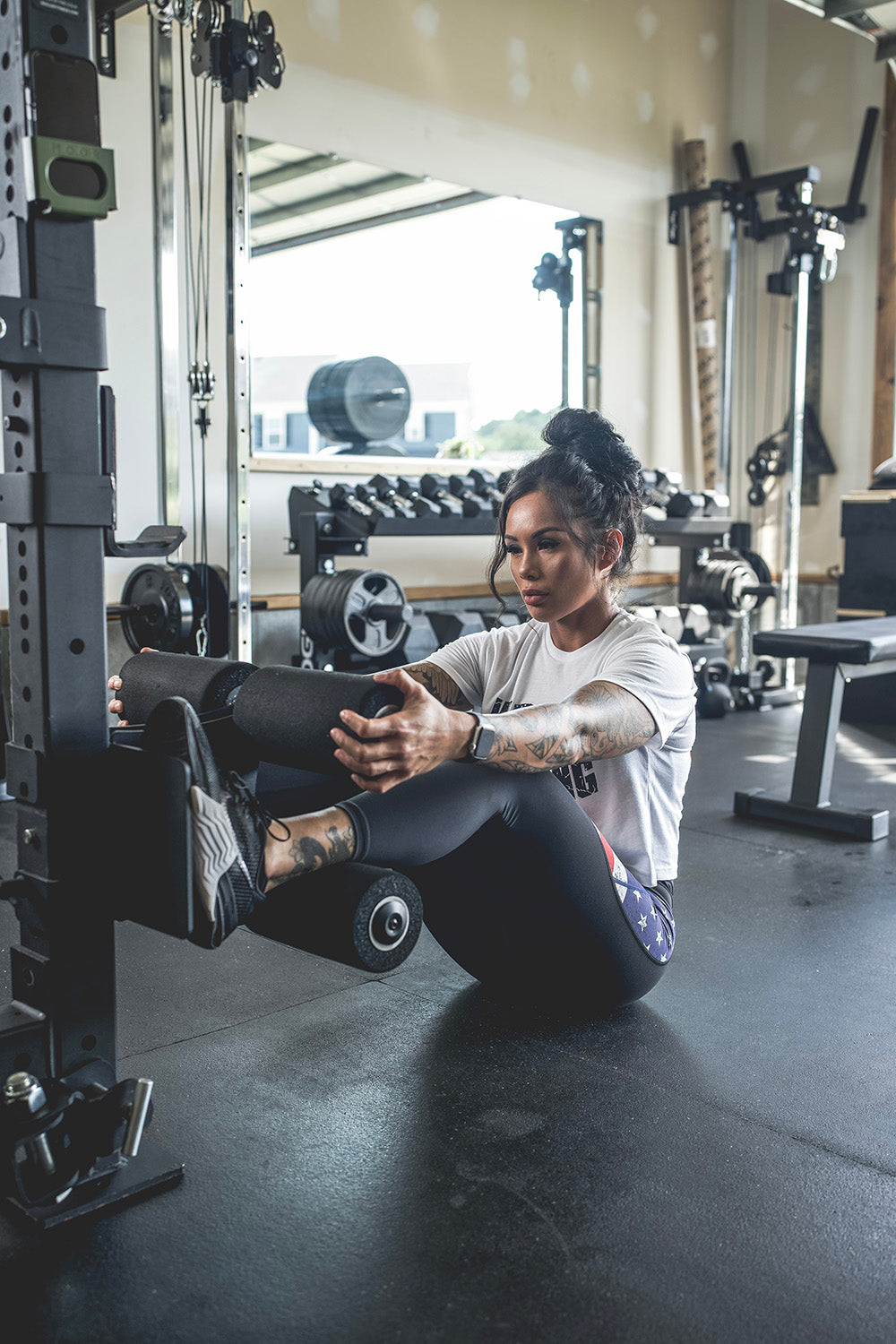 This Rack Mounted Glute Ham Developer is less bulky and lower priced than conventional GHDs. Perfect for glute workouts, ab workouts, and hamstring workouts. This image presents the Rack Mounted Glute Ham Developer being used by a woman for an ab workout.