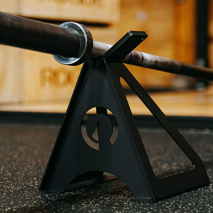 The Edge Landmine Jack is a compact landmine stand that takes the pain out of loading, reloading, and unloading heavy plates onto a barbell while using a landmine. This image presents the Edge Landmine Jack holding an empty barbell.