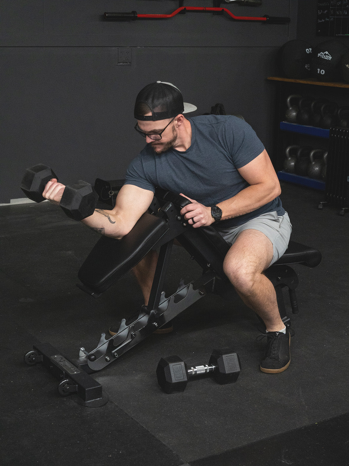 Man doing preacher curls in the Half Bench configuration on the Infinity Bench by Exponent Edge