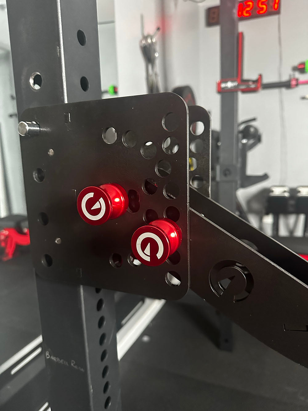 Custom Exponent Edge Magnetic pins fit all major brands of squat racks, power racks, and accessories, including Exponent Edge workout equipment. This image presents the Magnetic Edge Pins being used to attach workout equipment to a squat rack.