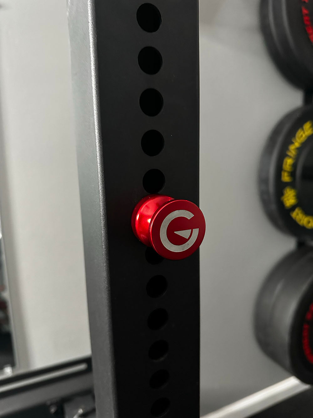 Custom Exponent Edge Magnetic pins fit all major brands of squat racks, power racks, and accessories, including Exponent Edge workout equipment. This image presents the Magnetic Edge Pin in red on a power rack from a front view.
