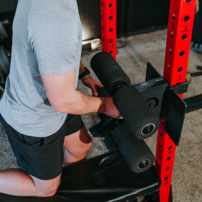 This Rack Mounted Glute Ham Developer is less bulky and lower priced than conventional GHDs. Perfect for glute workouts, ab workouts, and hamstring workouts. This image presents the Rack Mounted Glute Ham Developer being attached to a power rack.